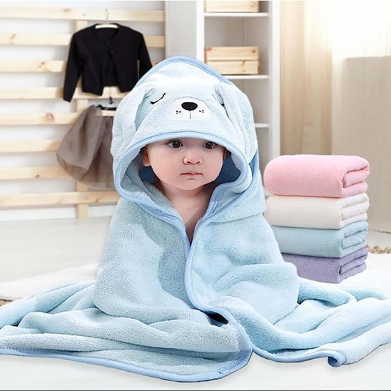 Cape de bain bébé bébé assis avec sa cape de bain bleu