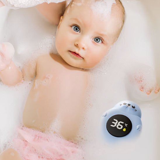 Thermometre bain bebe bébé dans le bain a coté de son thermomètre 