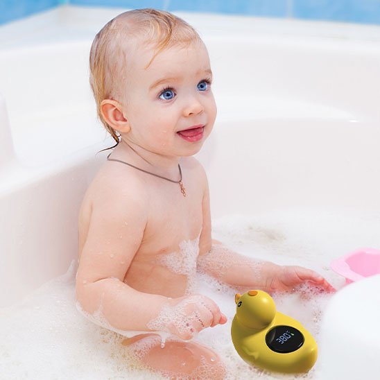 Thermomètre bain bébé bébé jouant avec son thermomètre dans le bain