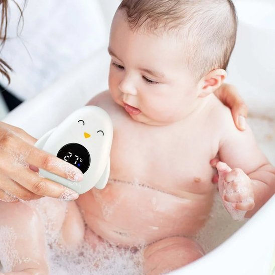 Thermomètre bain bébé bébé qui sourit en voyant son thermomètre